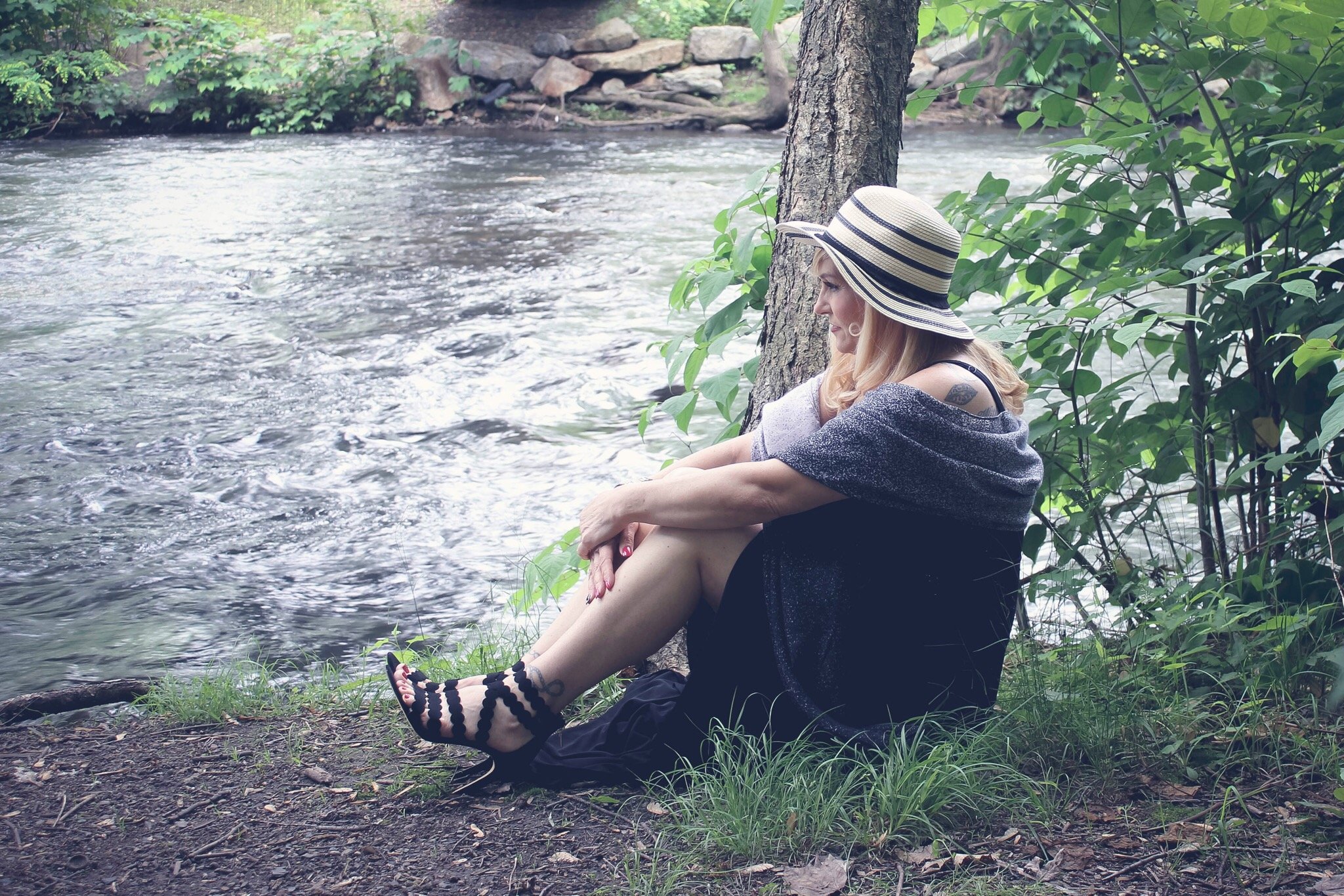 Woman sitting by river in heels