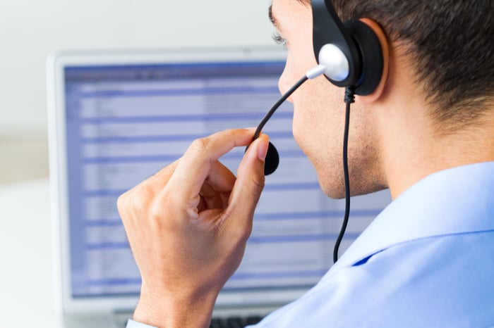 A customer service representative works in front of a screen.