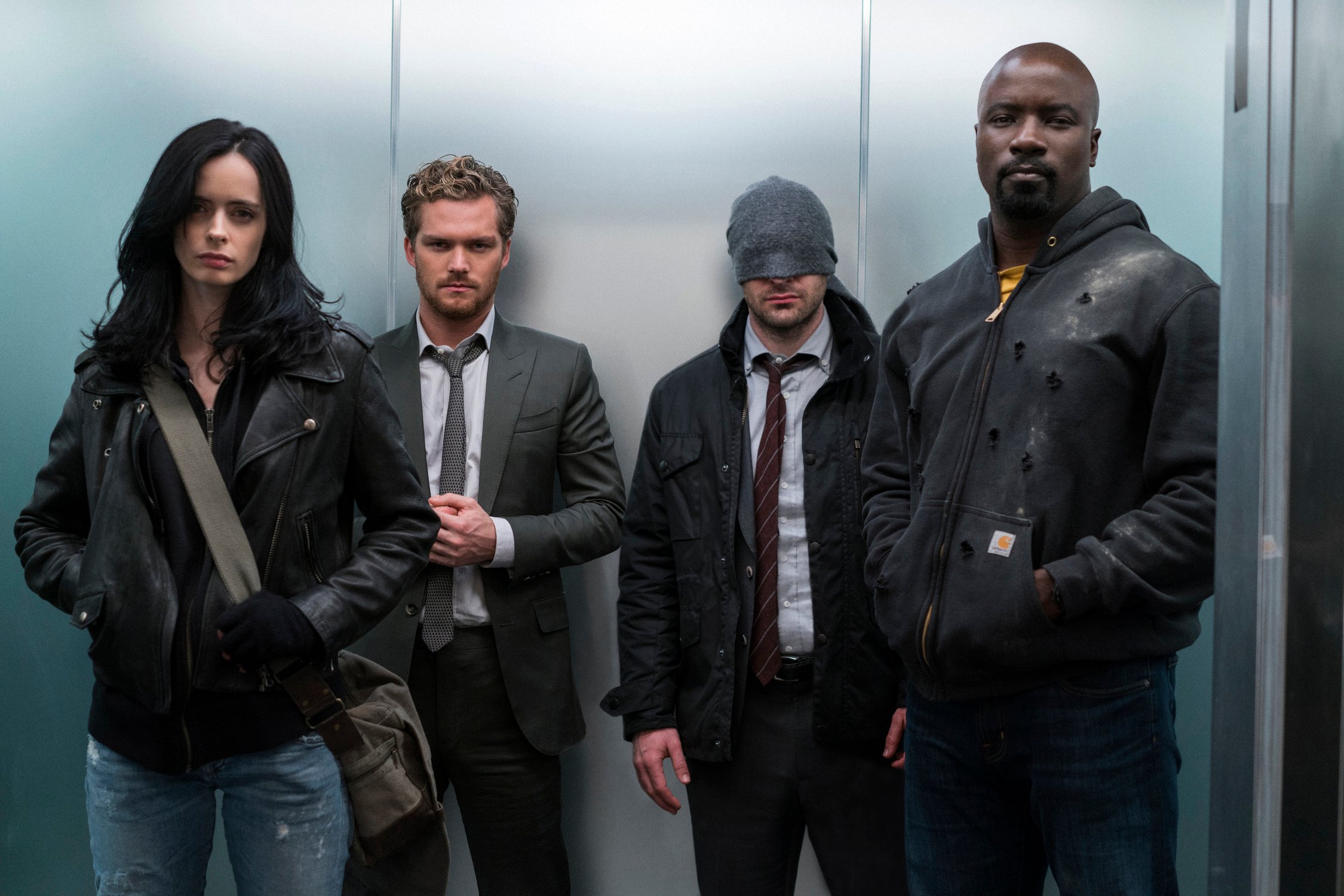 Four people standing in an elevator. 