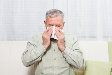 senior man blowing nose_GettyImages-518726596
