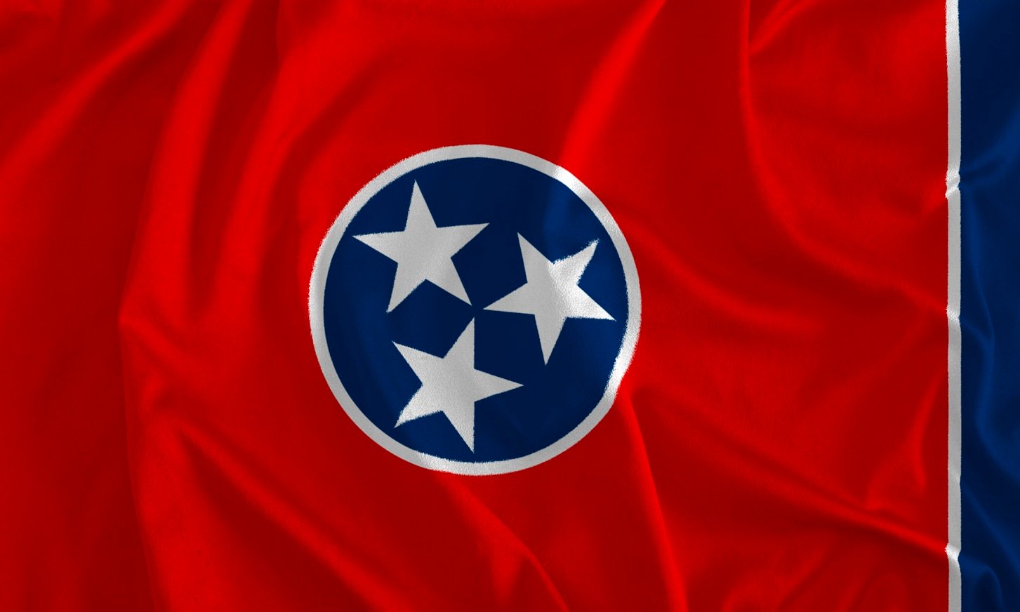 Flag with red background and centered circle with blue background and three white stars.