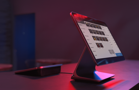 Square Register payment terminal on a countertop in dim light