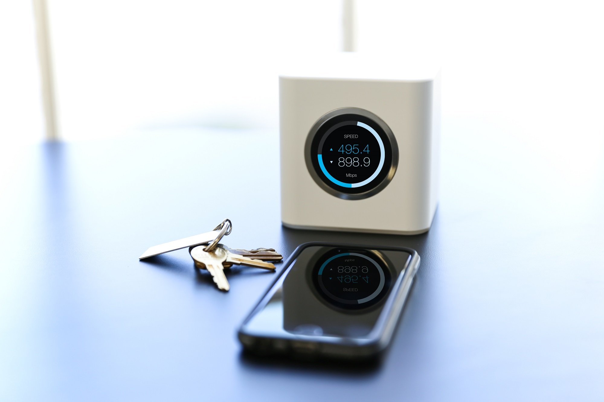 Ubiquiti Networks wireless router on a table next to a smartphone and keys