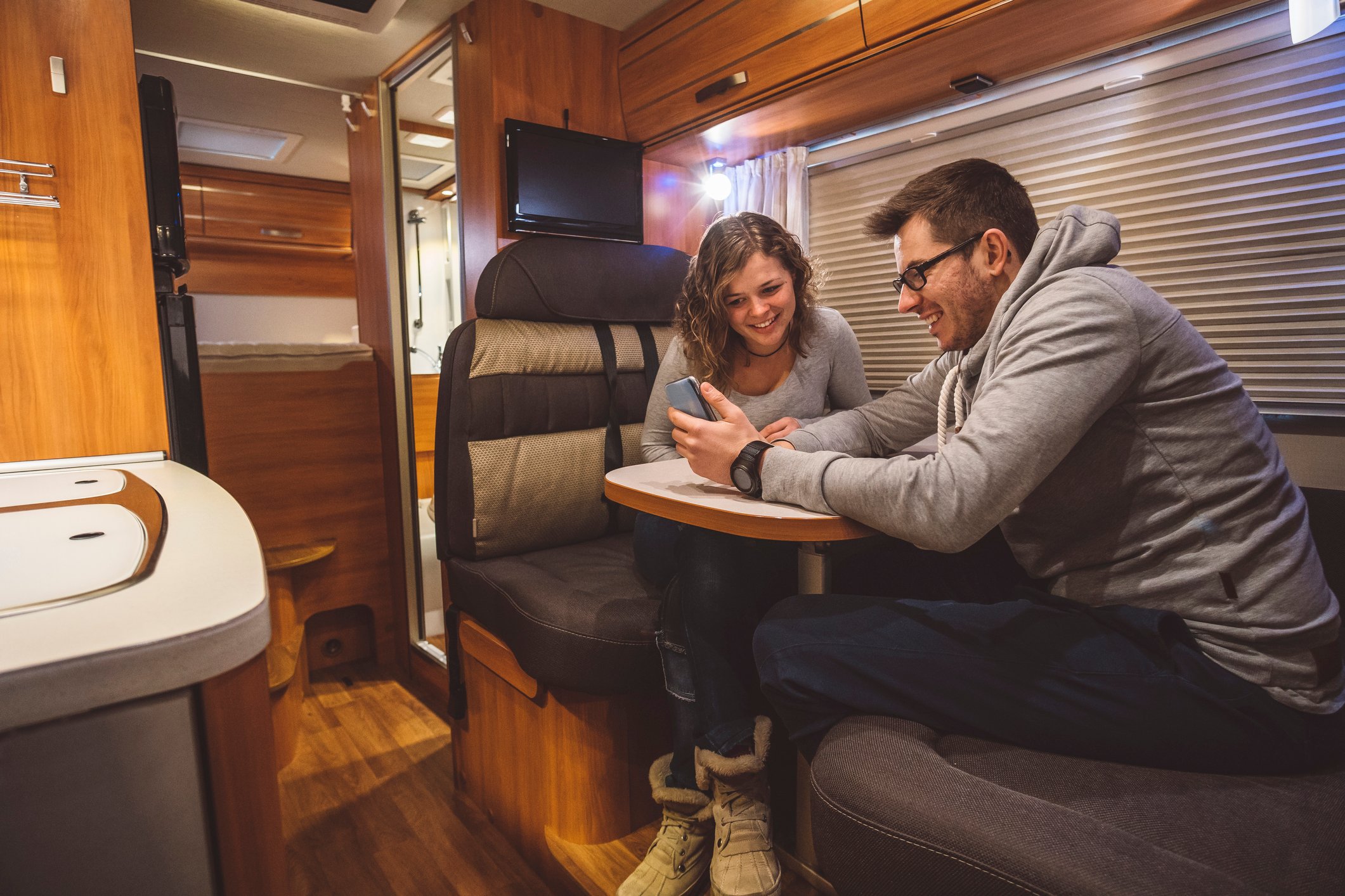 A couple sits inside a contemporary RV.
