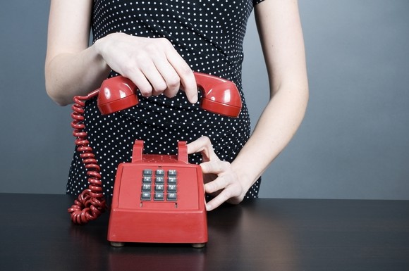Woman hanging up a red phone