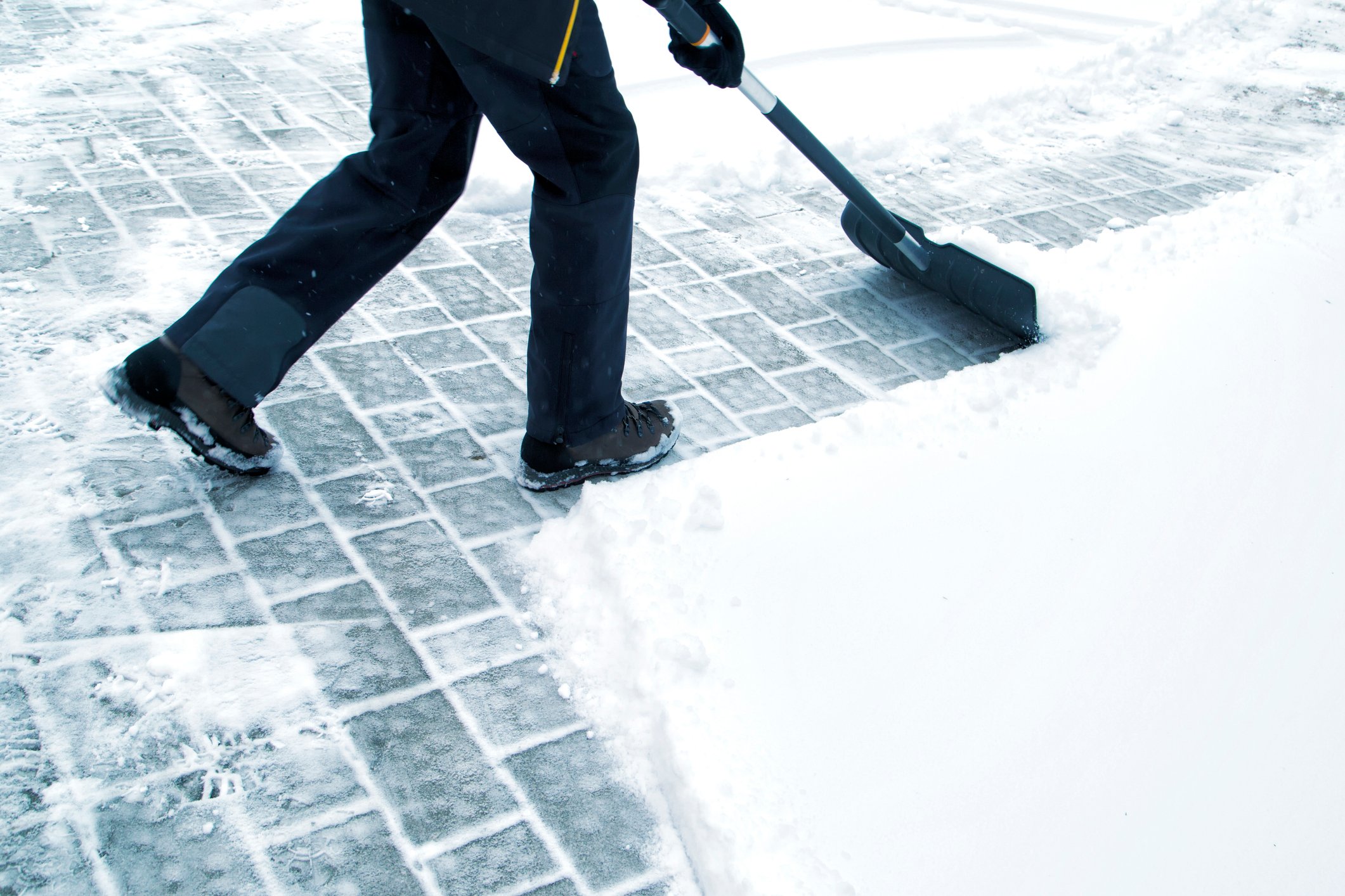 A person shovels a sidewalk.