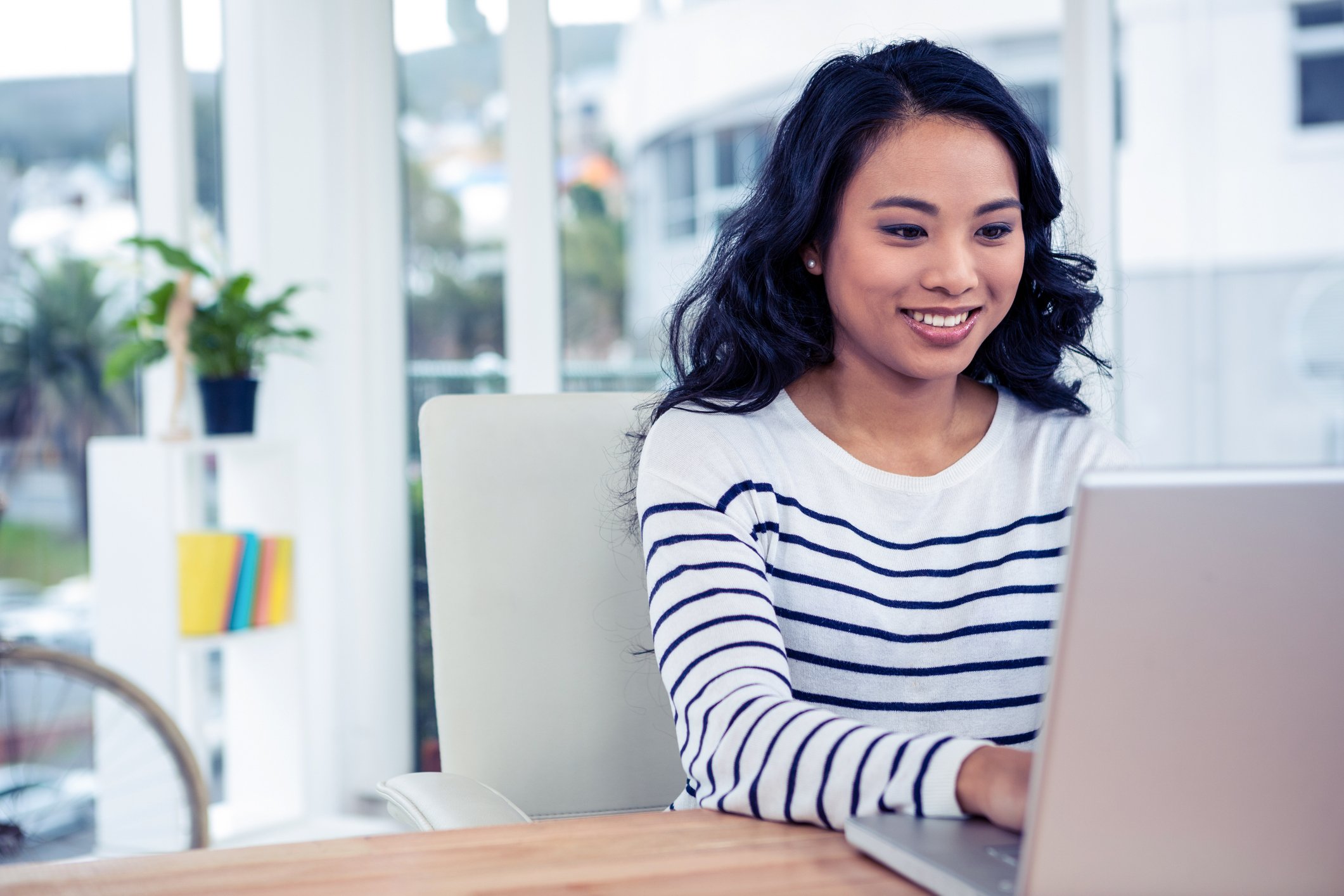 Young woman typing on laptop.