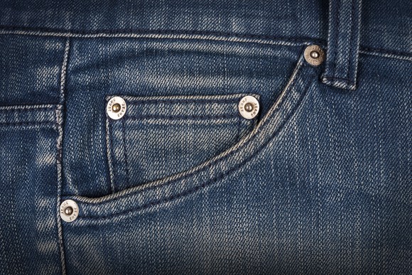 Close up of hip pocket on a pair of weathered blue jeans.