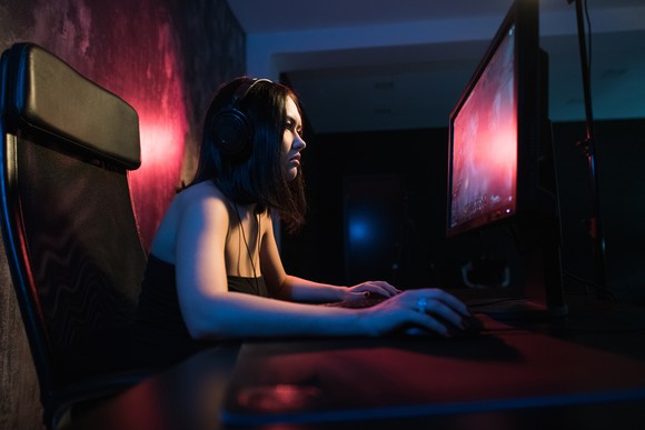  A young female gamer plays a PC game.