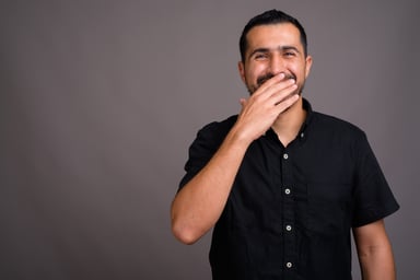 Man laughing with hand over his mouth