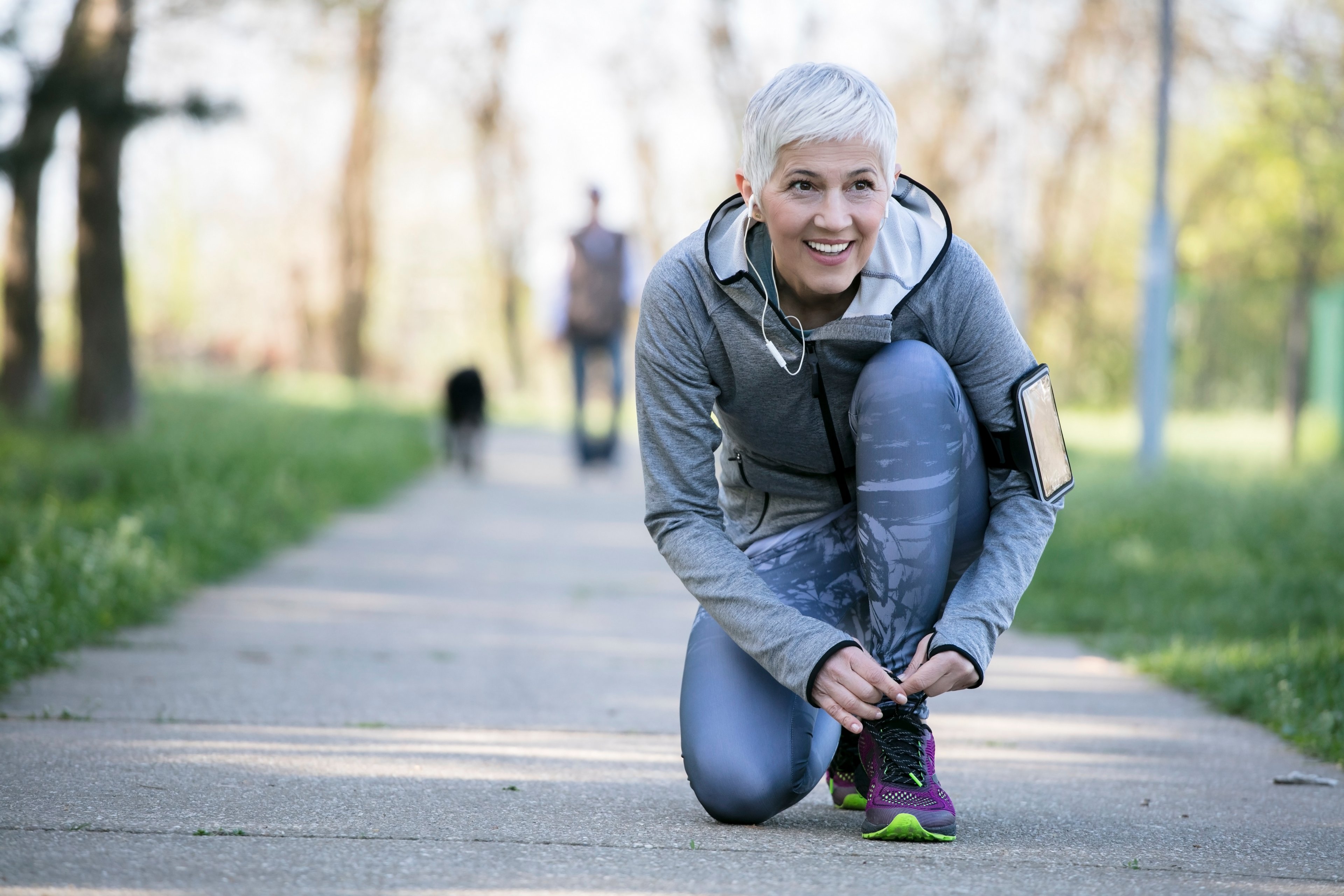 A woman bending down to tie her shoe