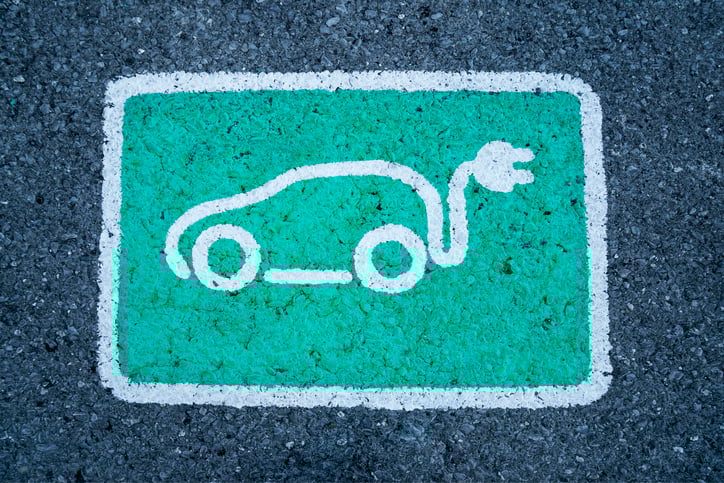 A drawing of a car with a plug on the pavement.