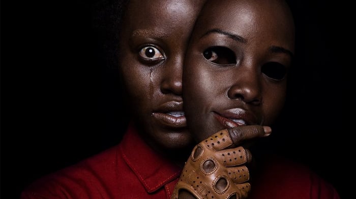 A poster from Jordan Peele's movie 'Us' shows a woman removing a mask.