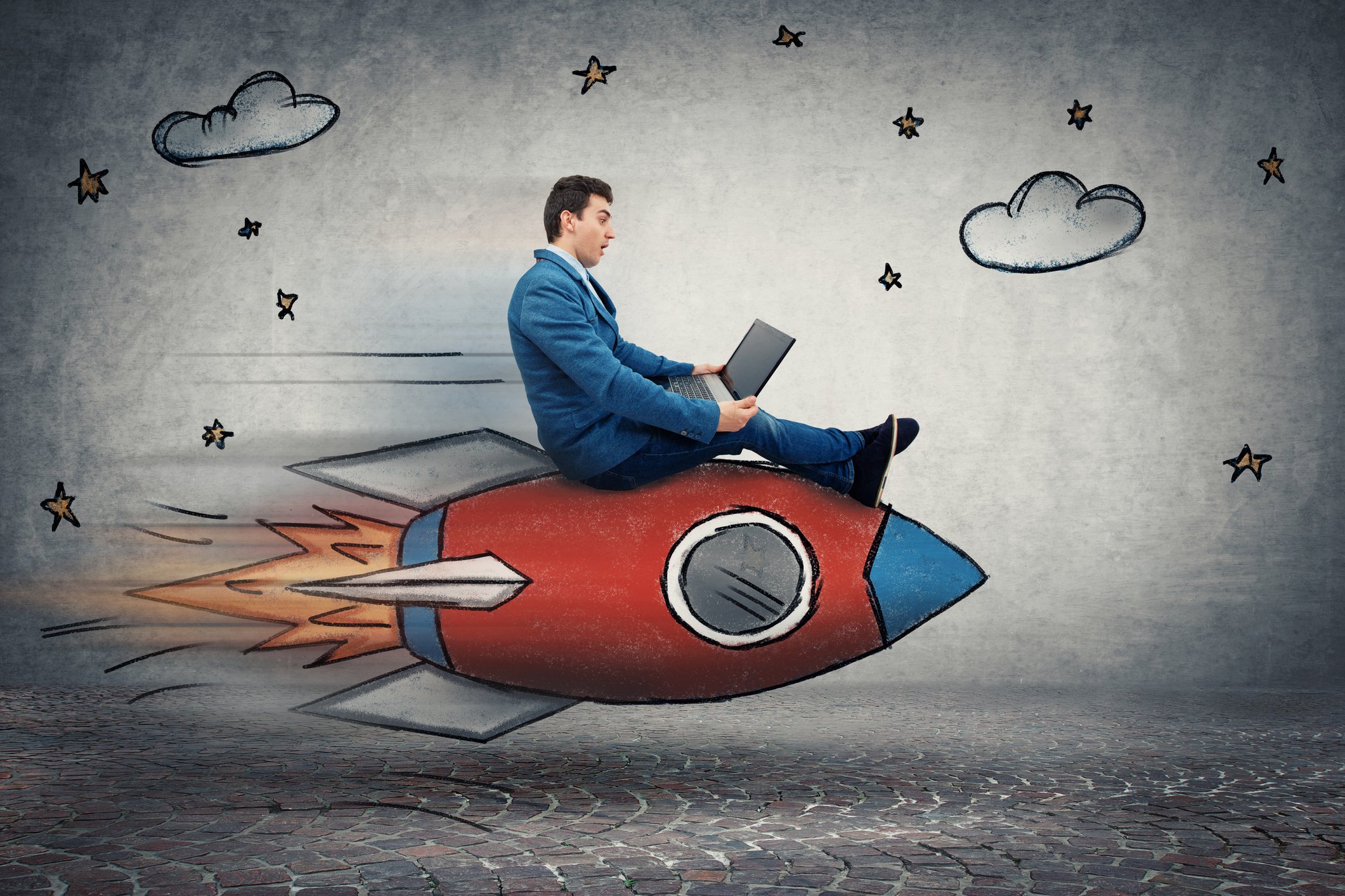 A man in a suit riding a toy rocket.