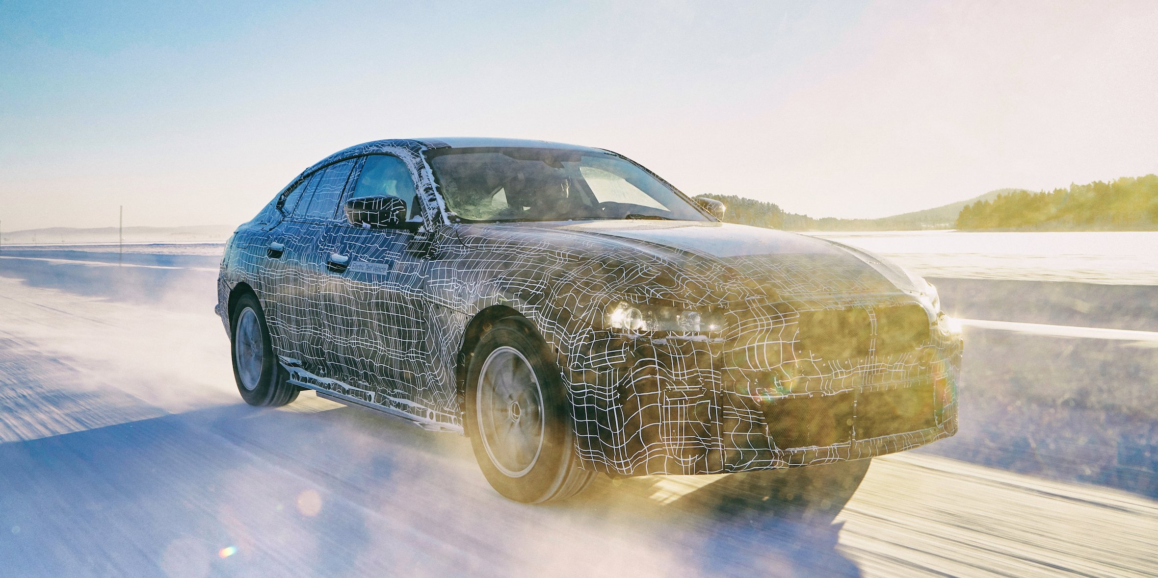 A prototype BMW i4, a midsize electric luxury-sports sedan, driving on snowy proving grounds