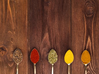 Spice Spoons on Wooden Background