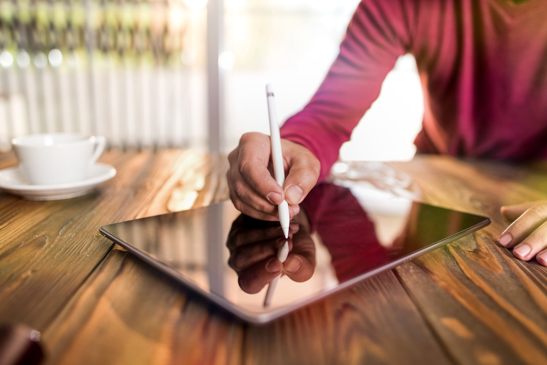 A person signing a document on a tablet device with a stylus.