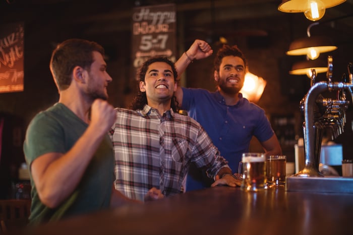 Three men cheering at a sports bar