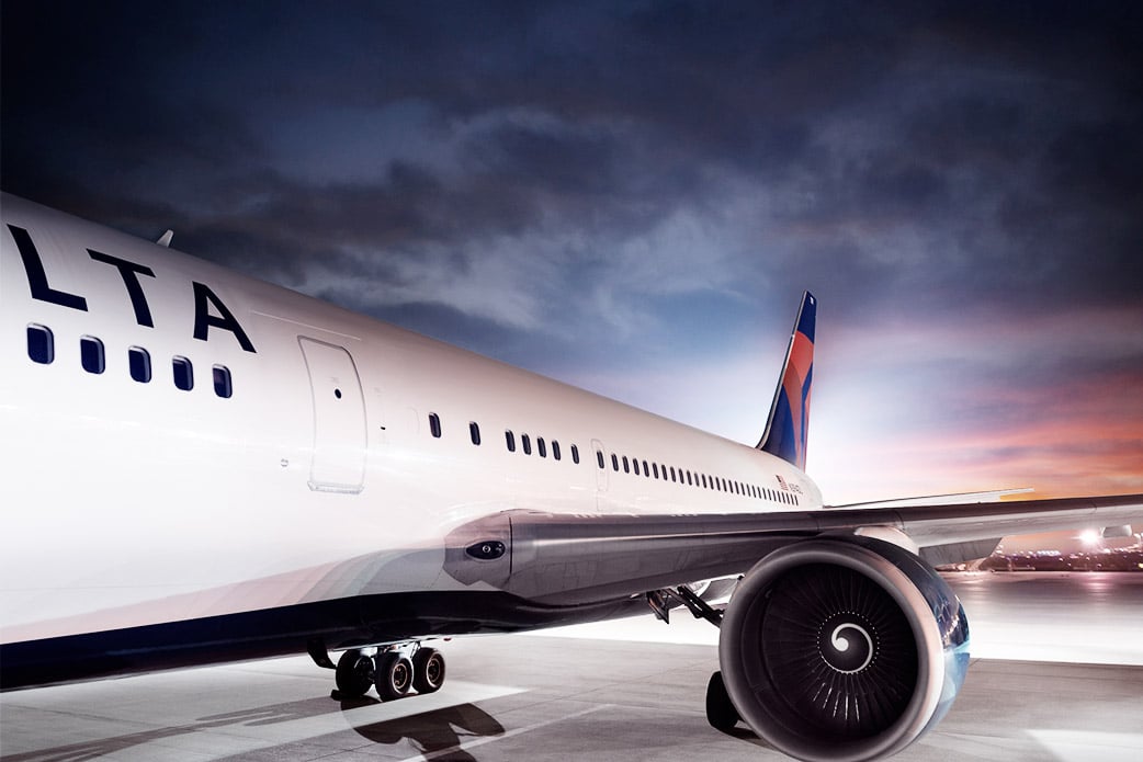 Airplane with Delta name and logo marked on it, against a dusky background sky