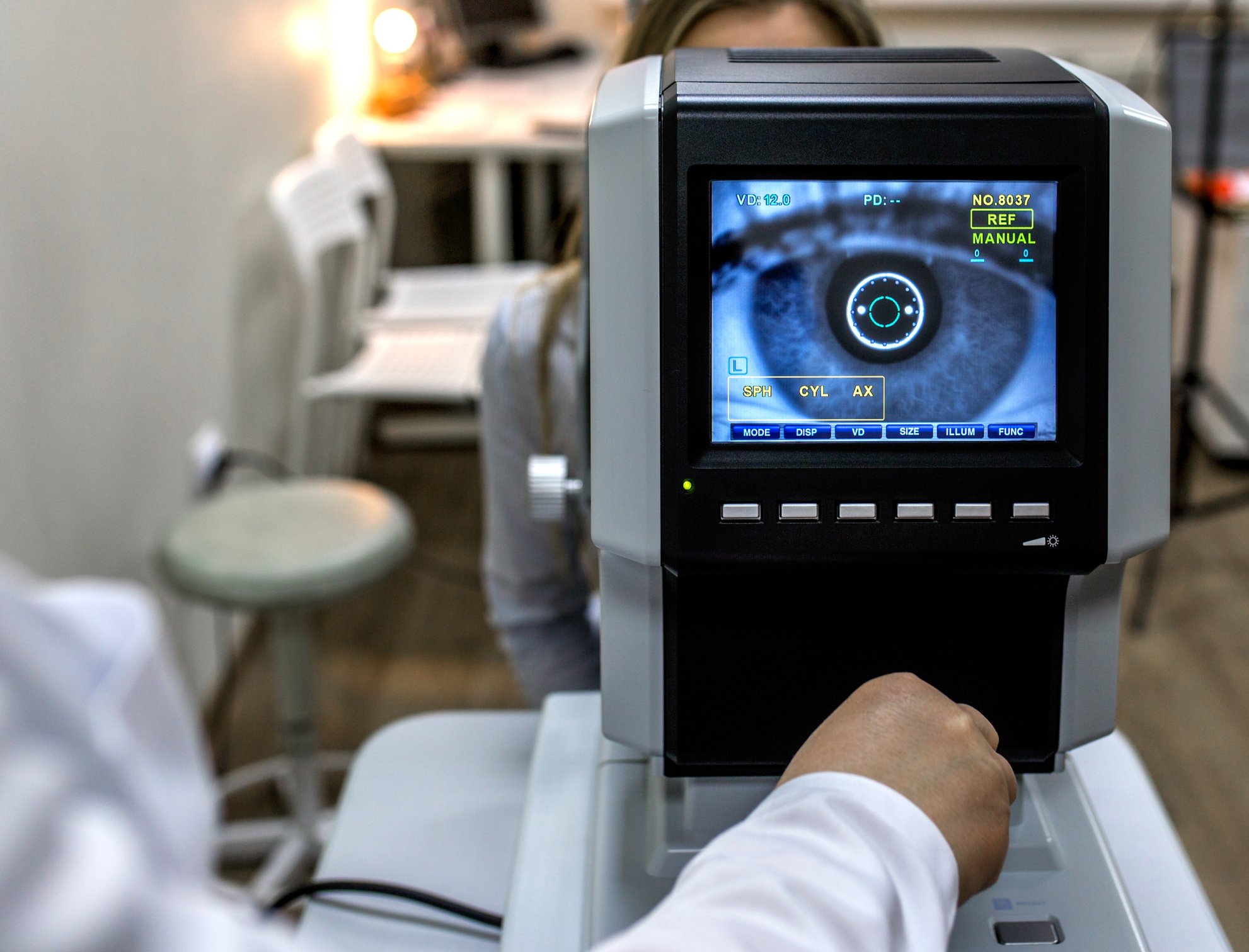 Image of woman's eye on a screen facing a person, presumably a healthcare professional who is examining the woman's eyes/vision. 