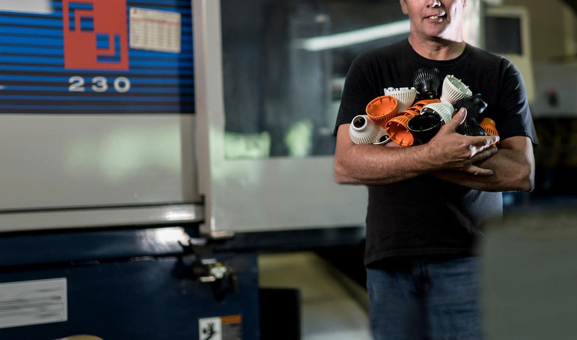 A man holding parts made by 3D Systems' Prox Dmp 300 3D printer.