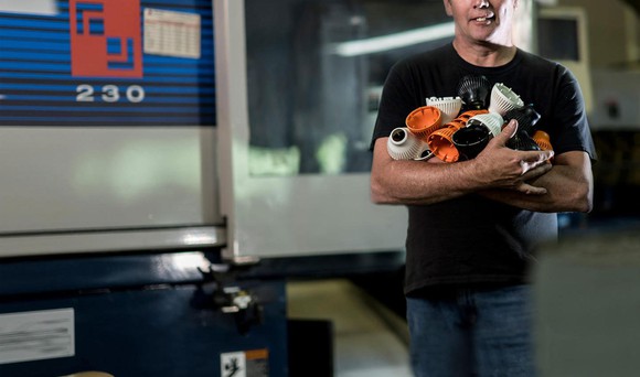 A man holding parts made by 3D Systems' Prox Dmp 300 3D printer.