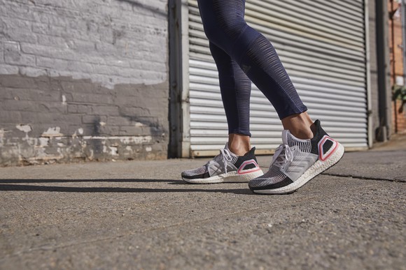 A woman wears a pair of Adidas sneakers.