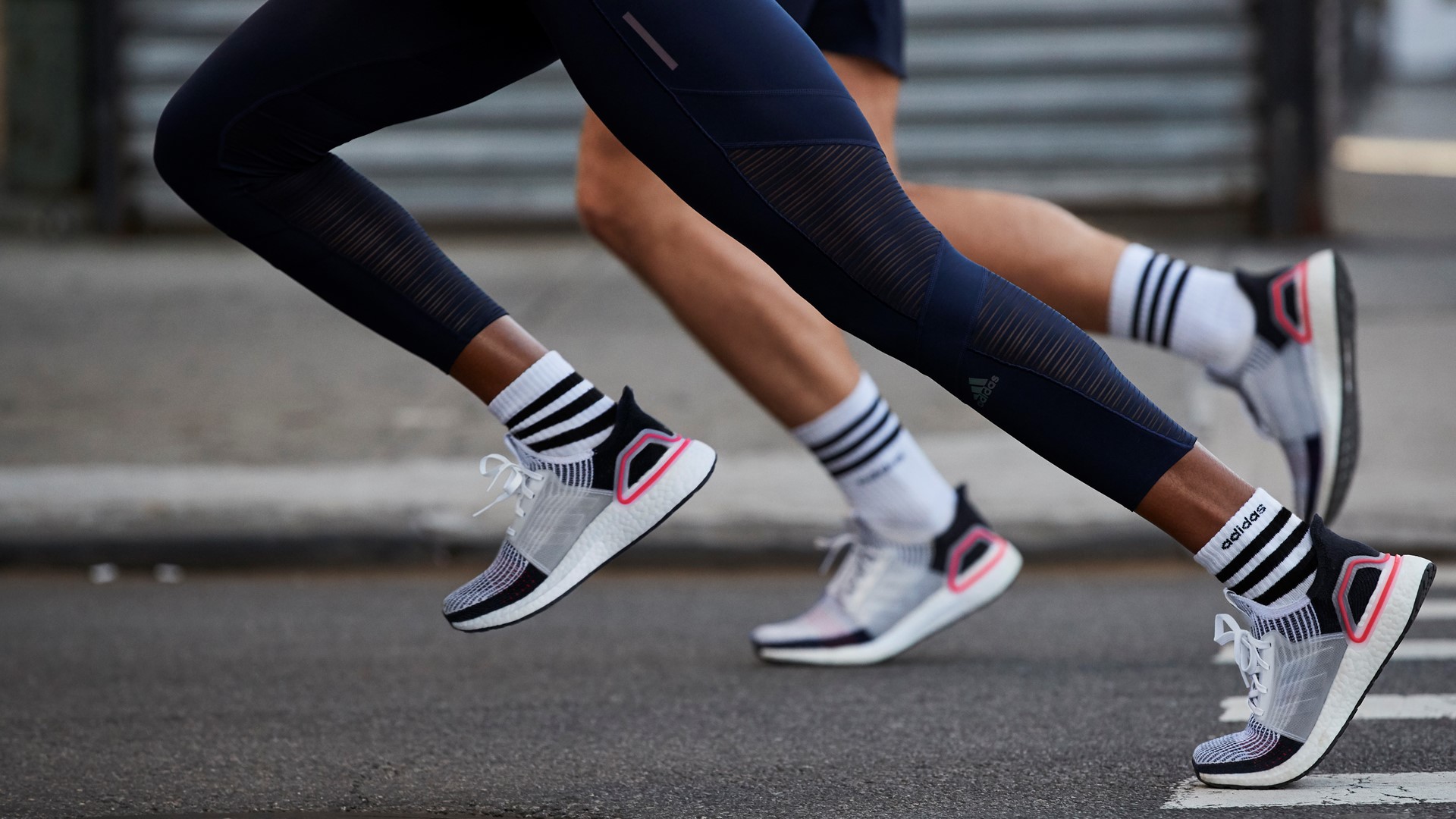 Two runners running in Adidas UltraBoost shoes.