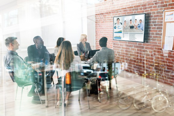 Business team meeting with co-workers in a conference room via video conferencing