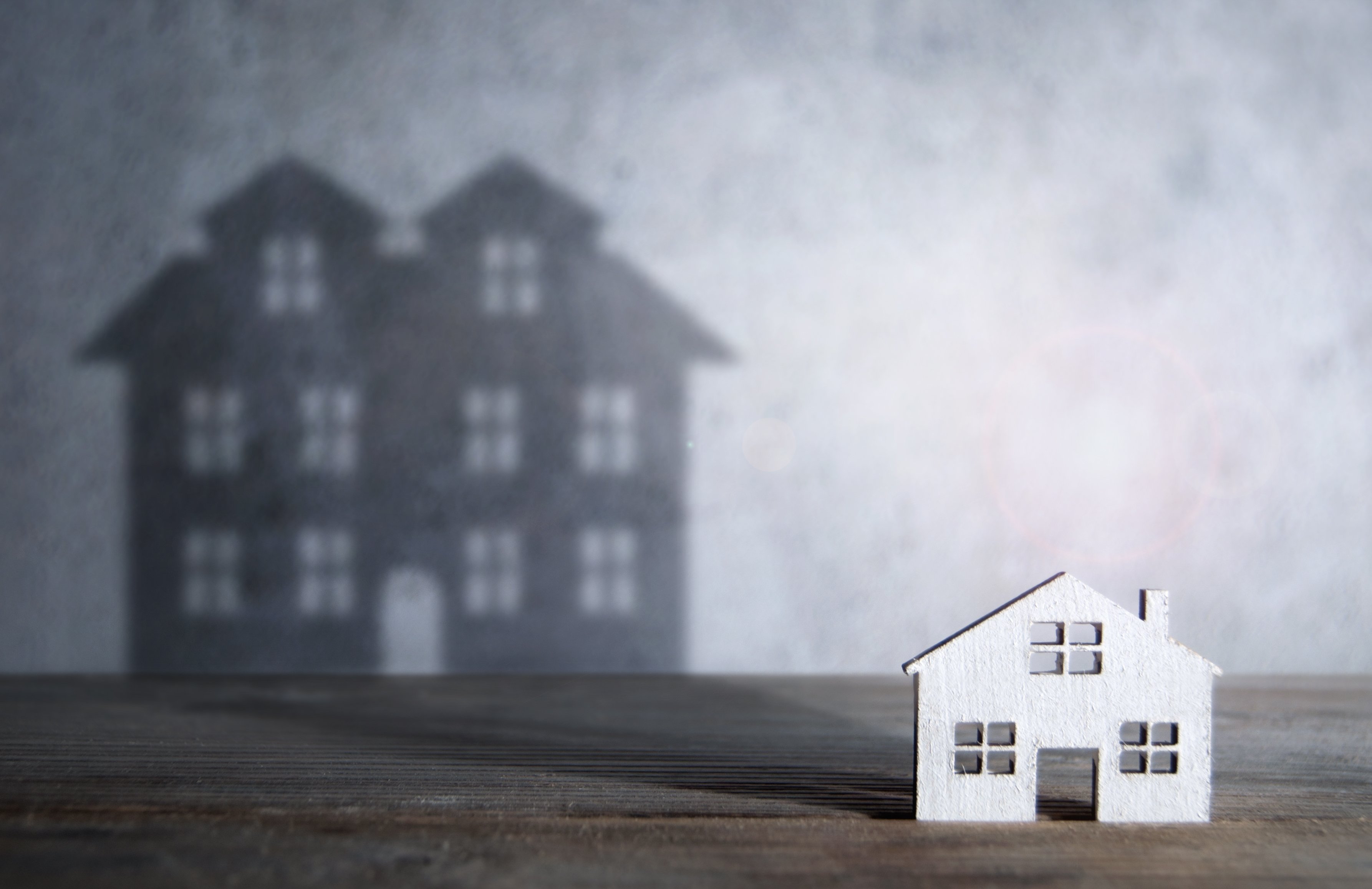 A house with a shadow of a bigger house