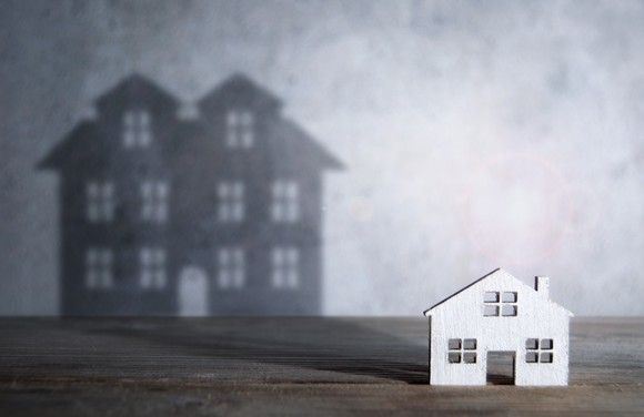 A house with a shadow of a bigger house