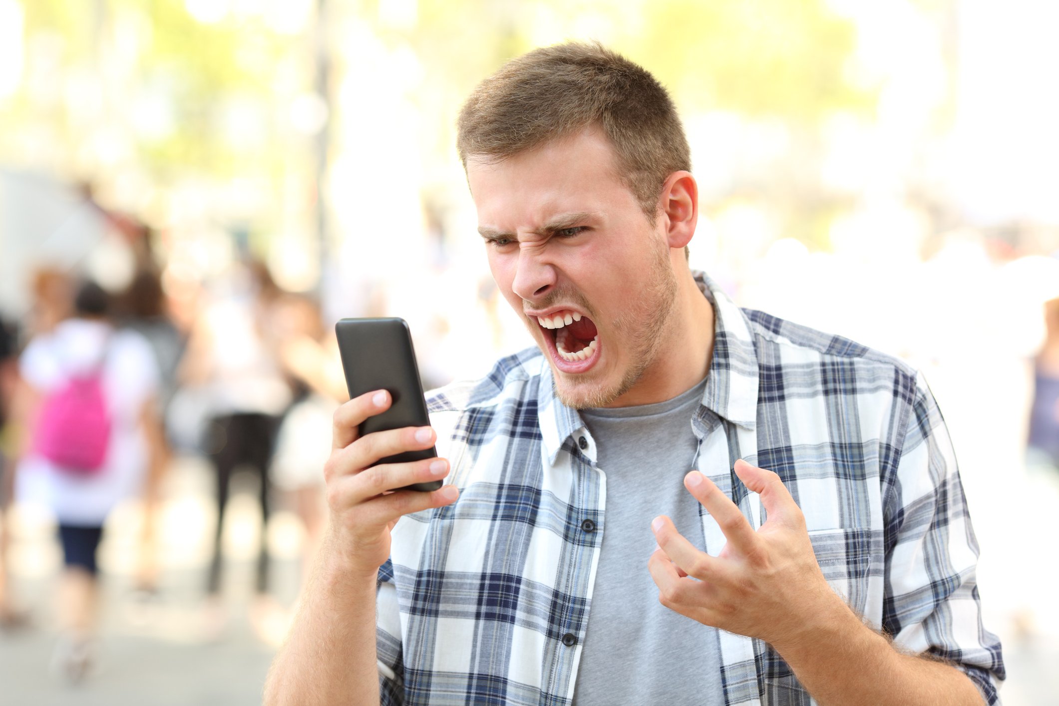 Young man yelling at his cell phone.