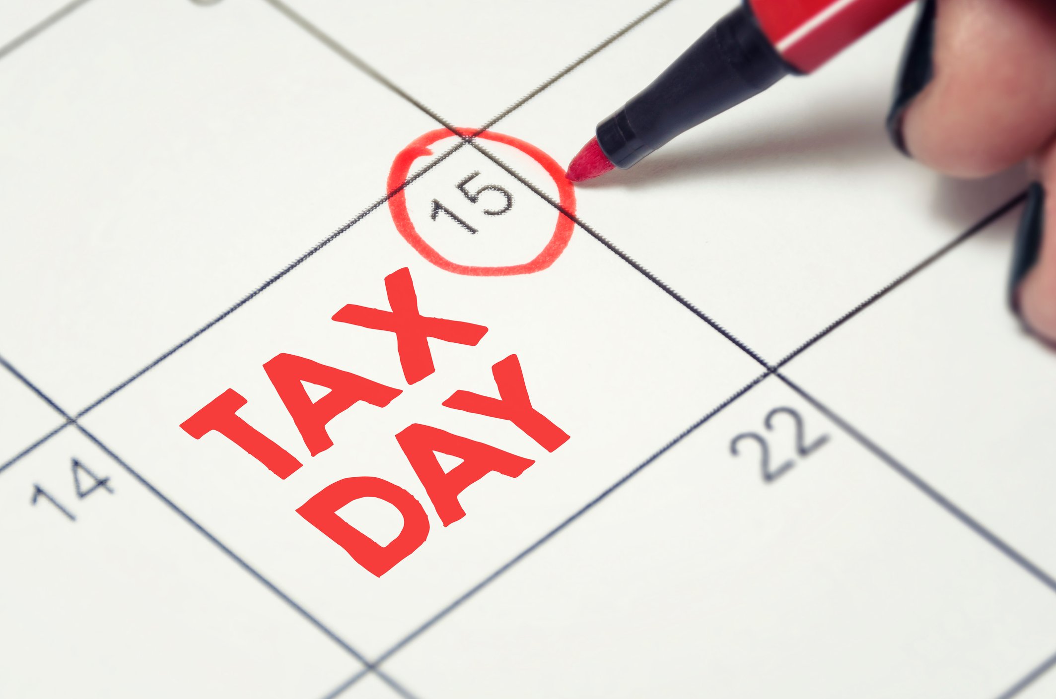 April 15 date circled in red on calendar, with the words TAX DAY written in red letters on that calendar square.
