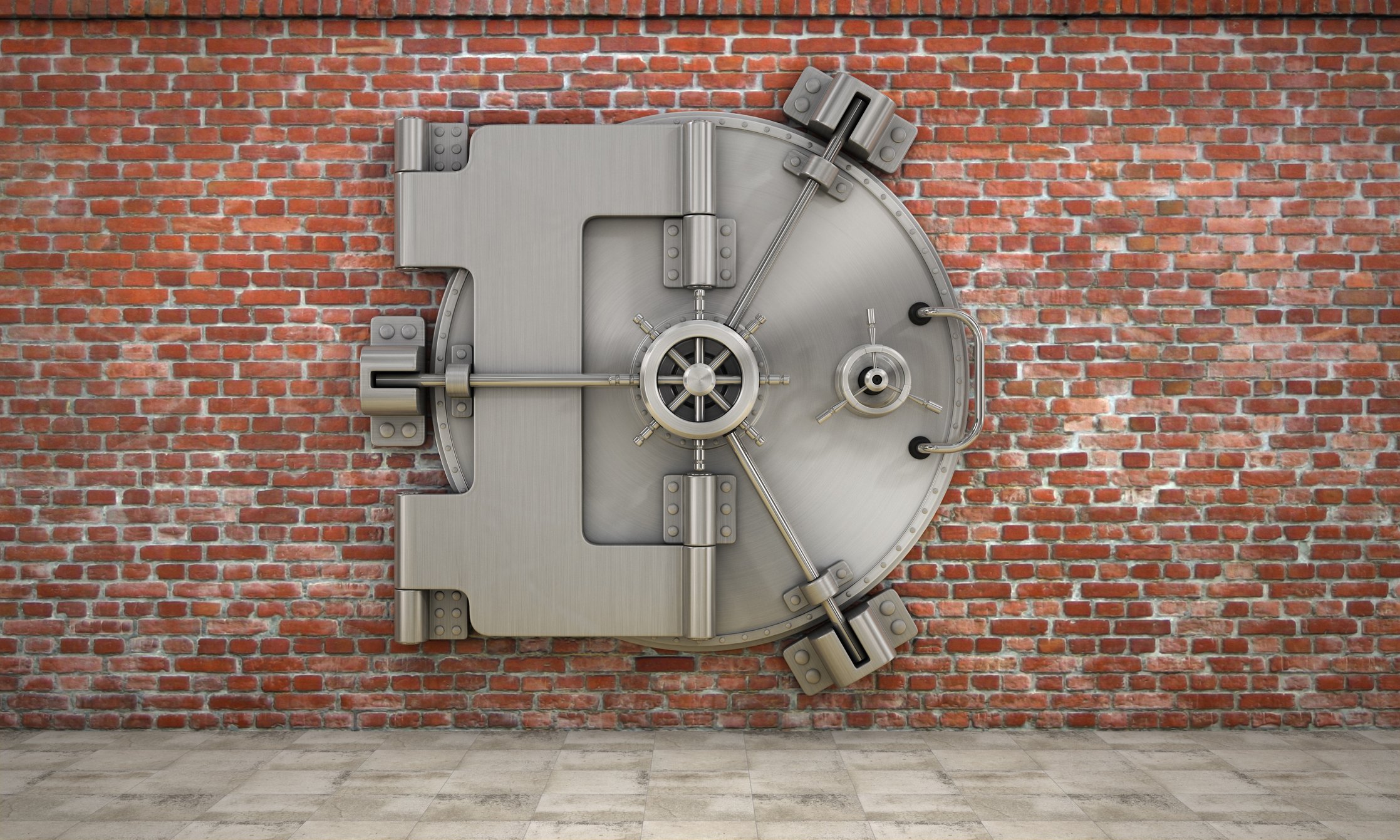 A bank vault against a brick wall.
