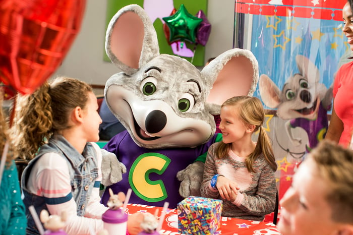 Chuck E Cheese mouse mascot with two young girls