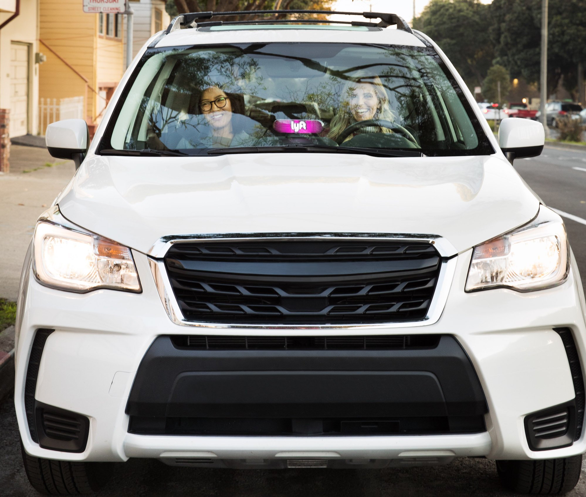 Two women sitting ina a white car.