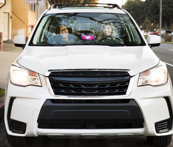 Two women sitting ina a white car.