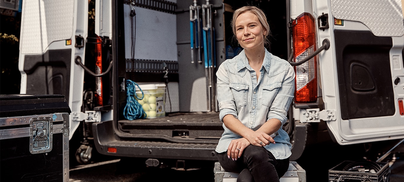 Woman sitting on truck tailgate holding Juul electronic cigarette