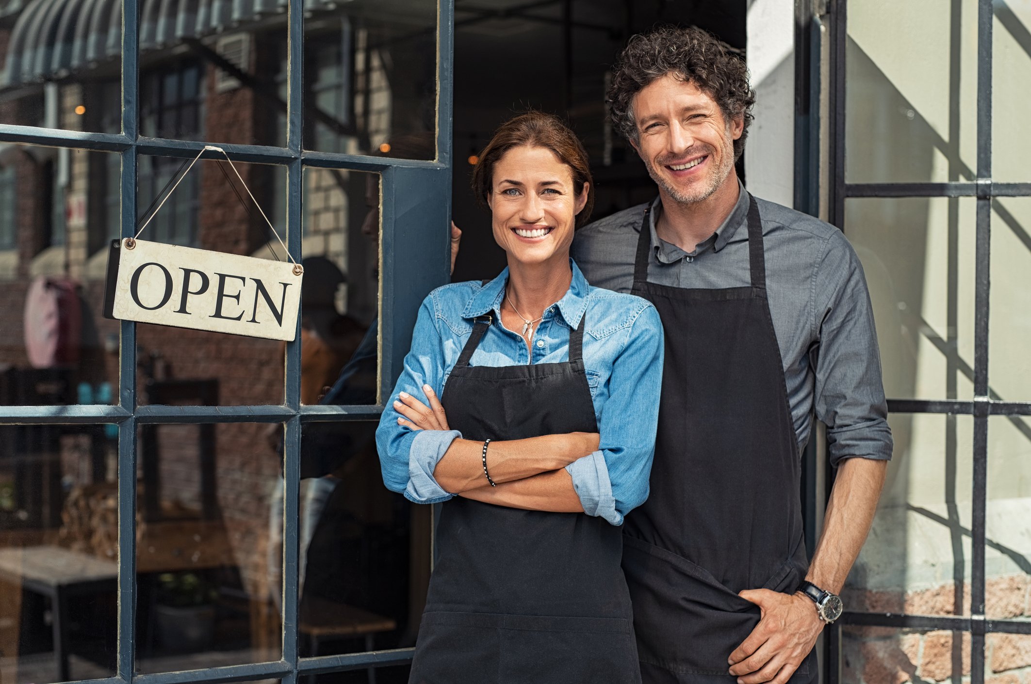 A man and a woman stand in front of a busness.