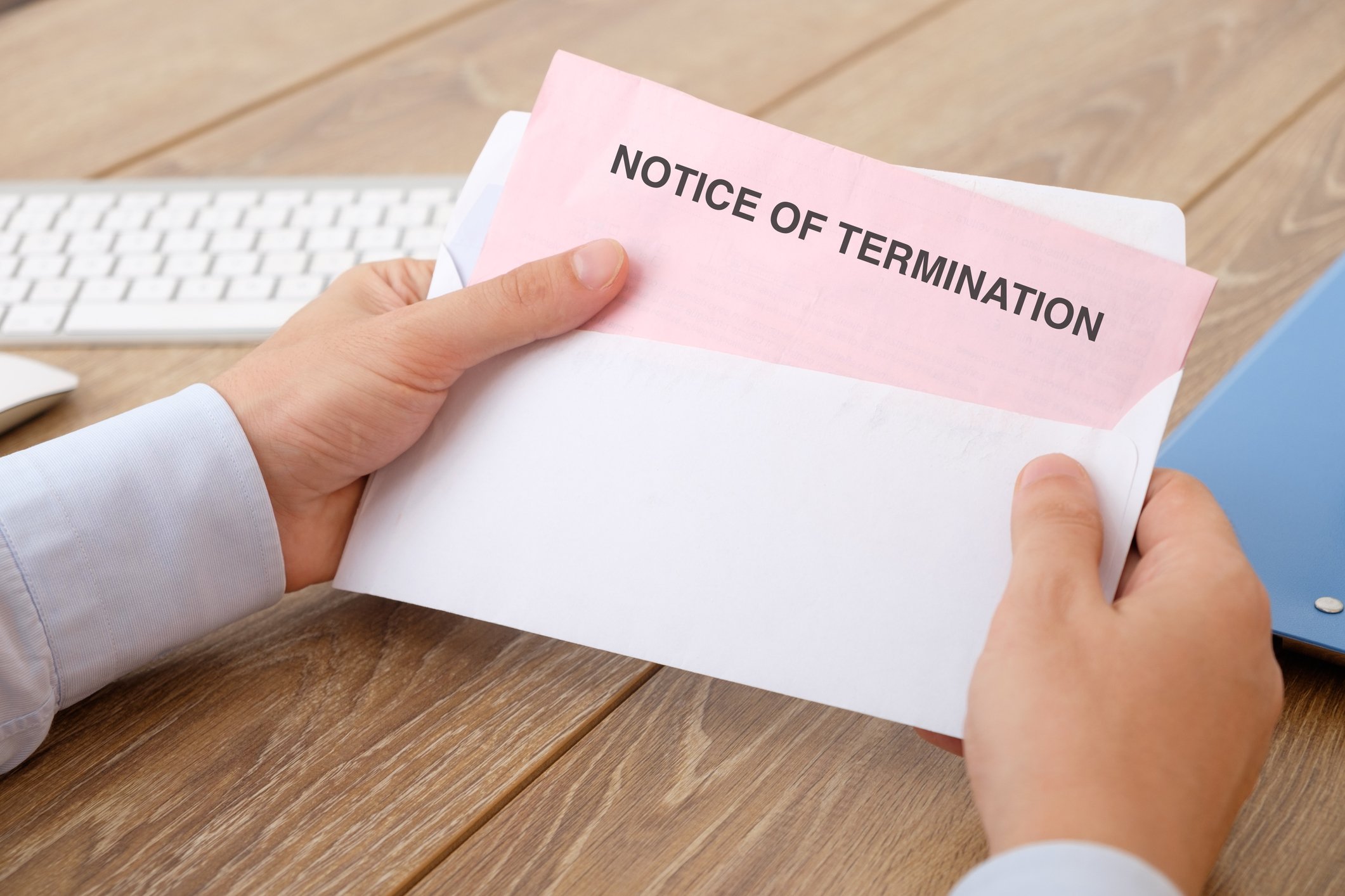 Man holding envelope with pink notice of termination sticking out