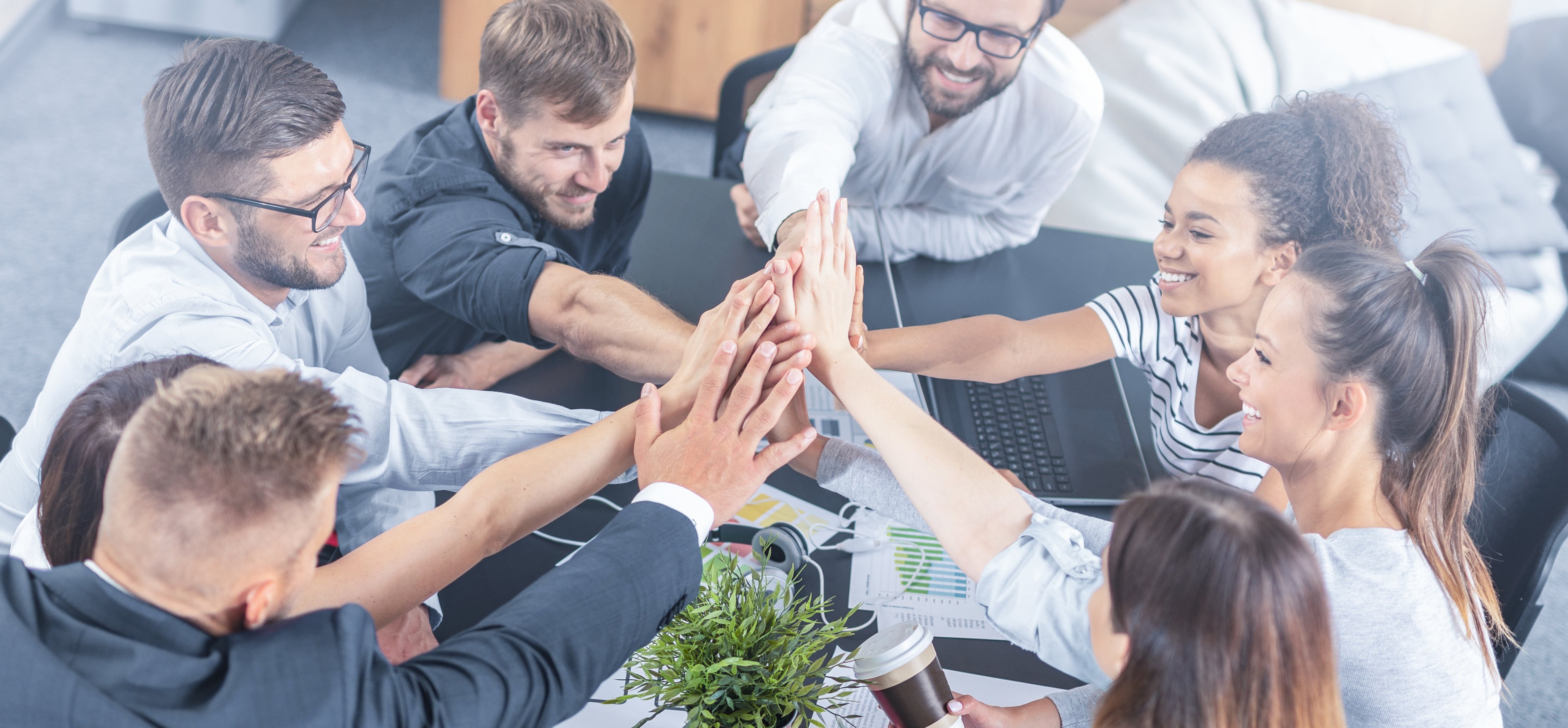 Group of young adults in a circle high-fiving