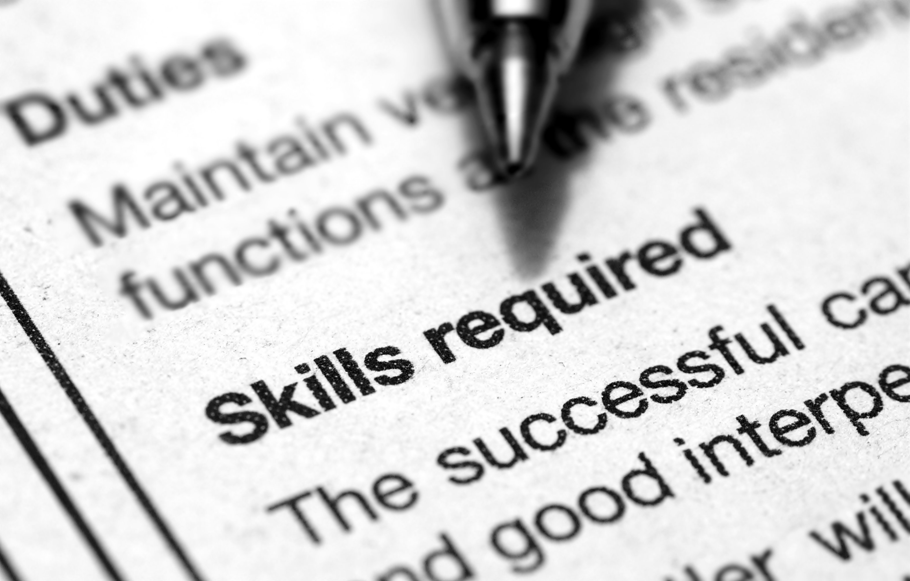 Pen hovering over skills required section of a job listing