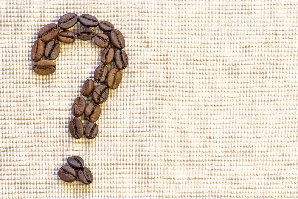 Coffee beans arranged in the shape of a question mark. 