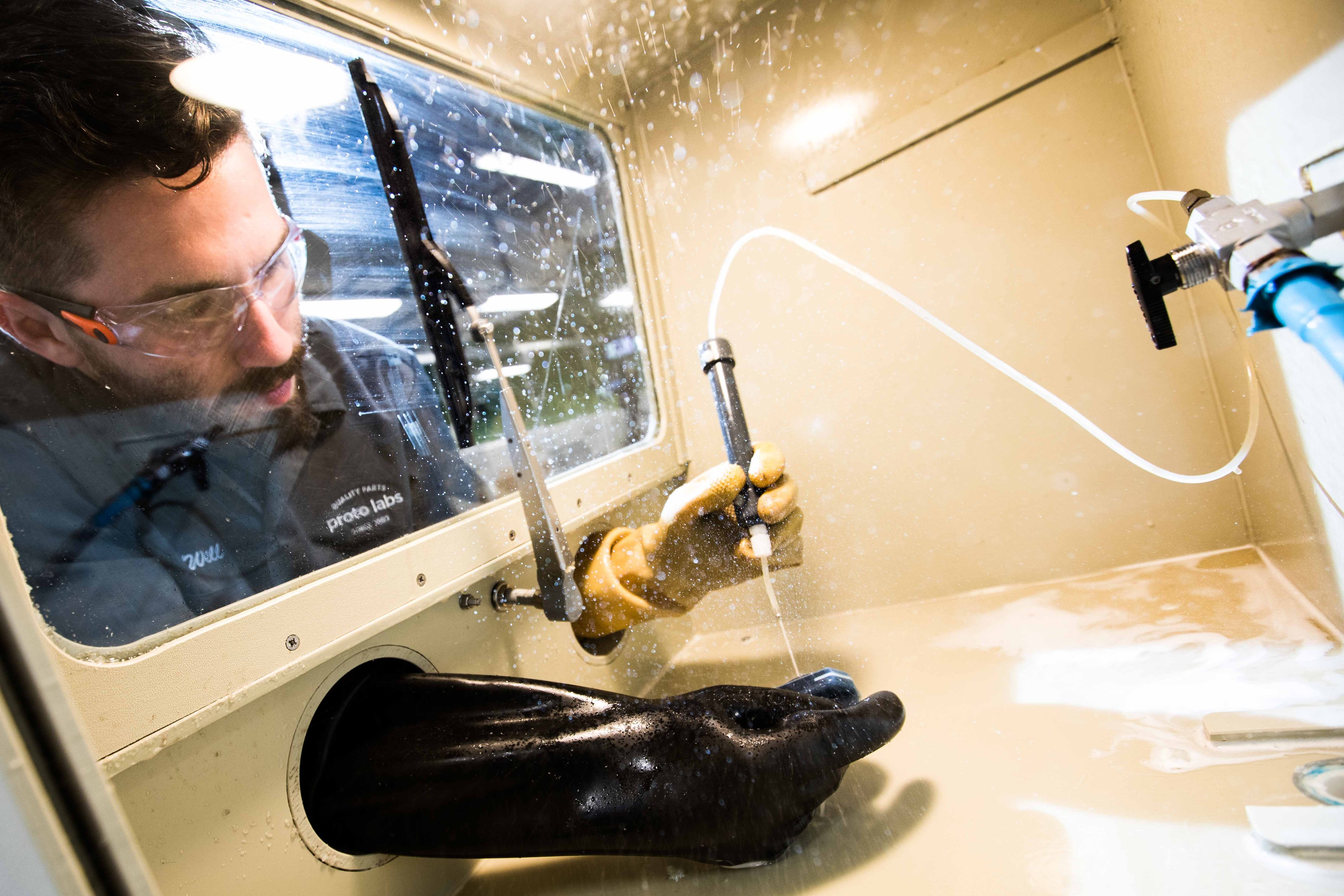 A technician does finishing work on a PolyJet 3D printed item.