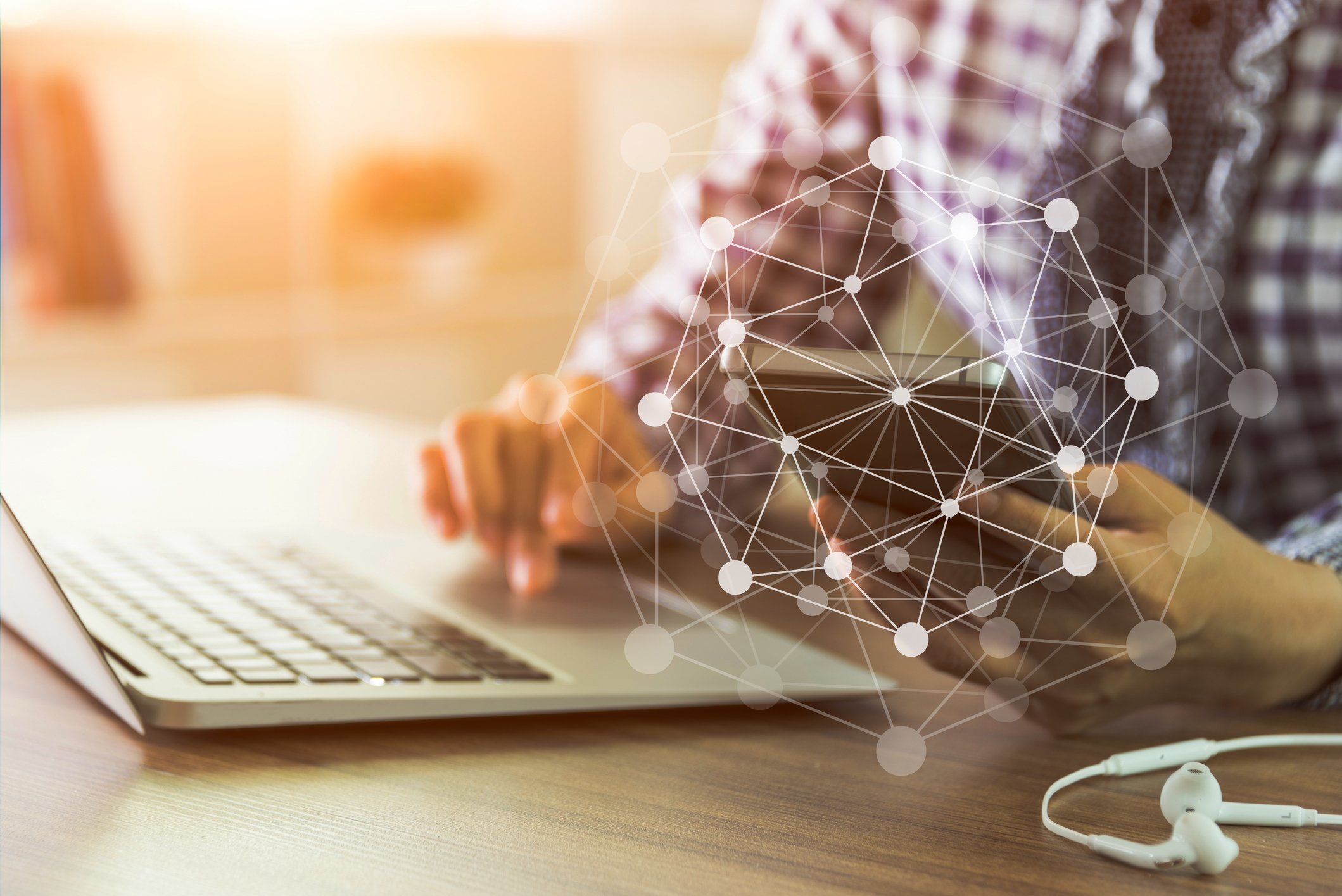 A geometric graphic suggesting interconnectedness is superimposed over a man touching the track pad of a laptop.