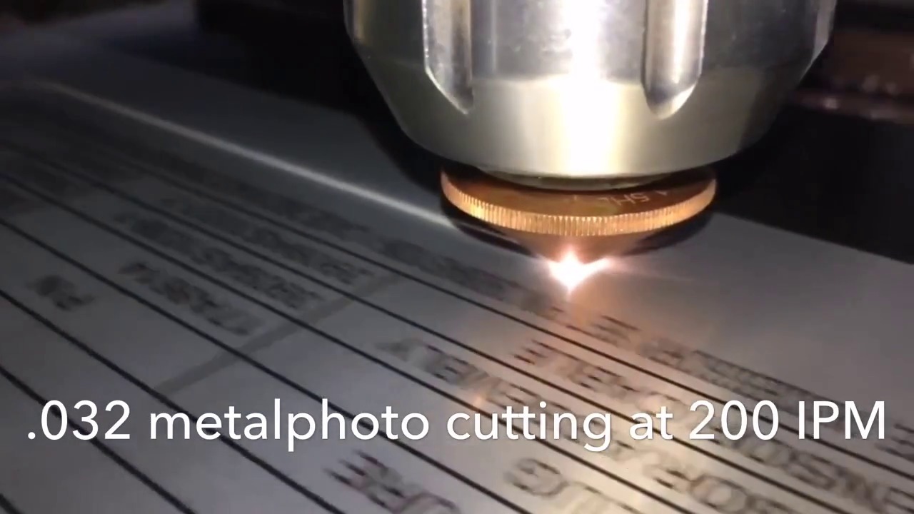 Laser in a large cylinder aimed at and cutting a thin piece of metal