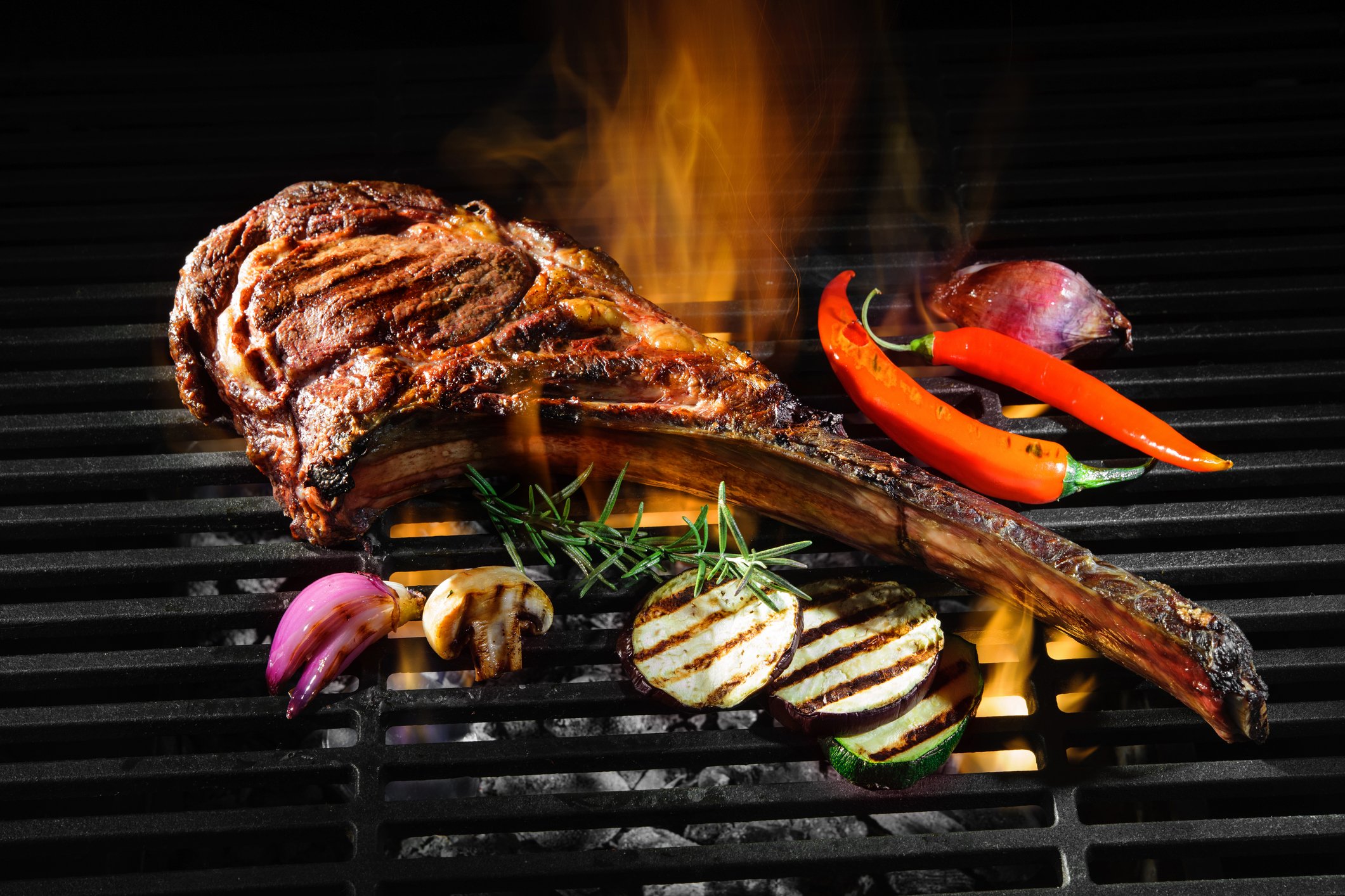 A steak and vegetables on a grill