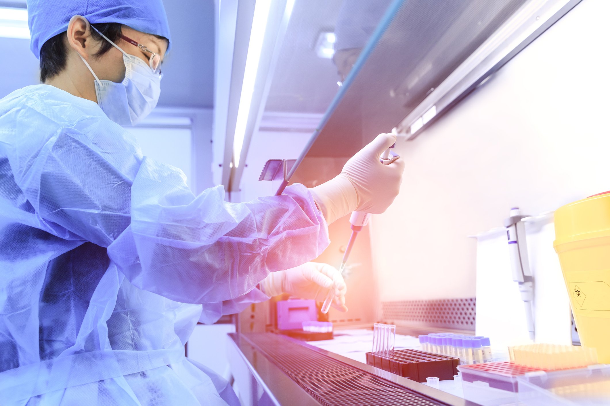 Scientist working in a lab with vials of drugs in front of her