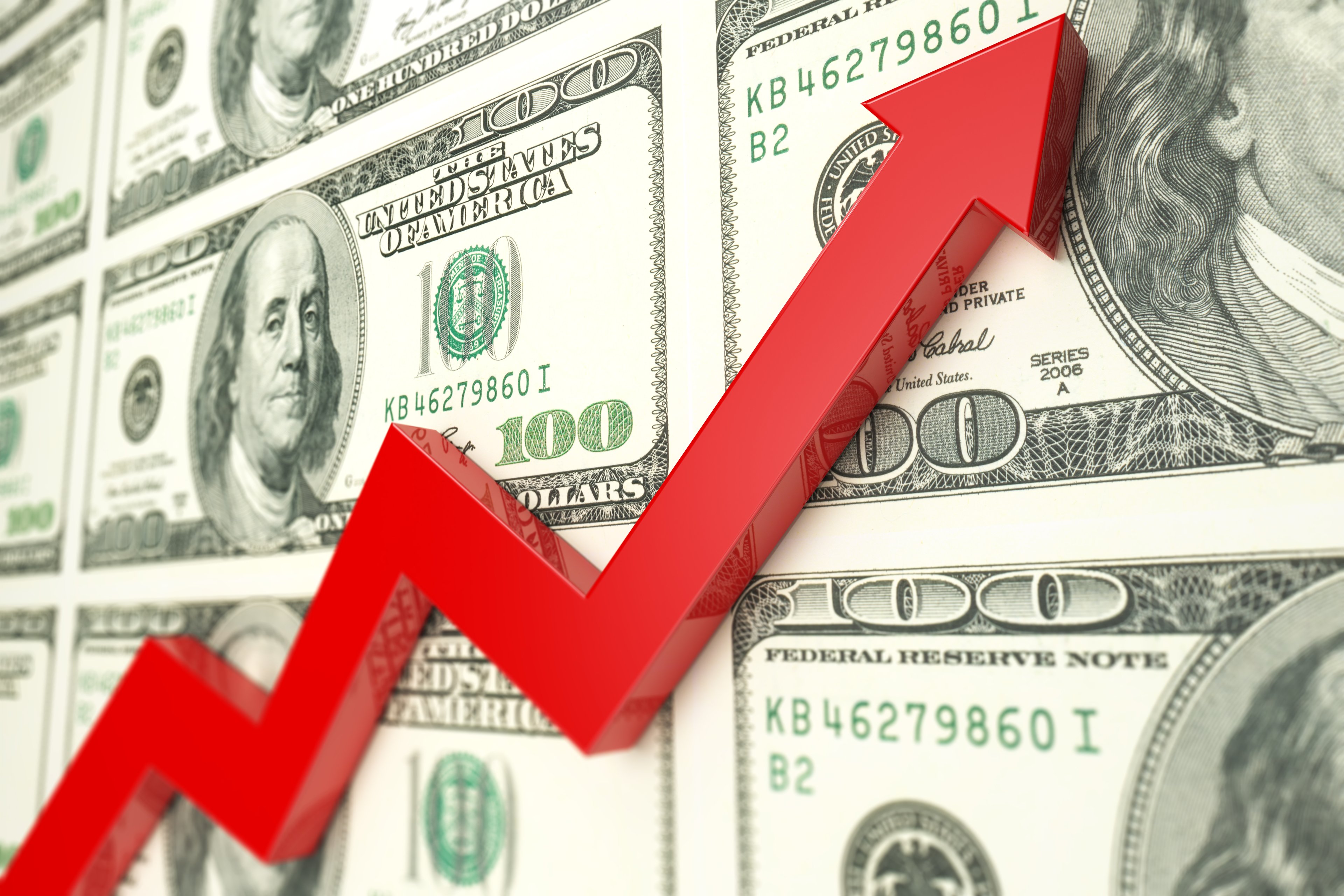 An arrow moving up against a backdrop of hundred-dollar bills.