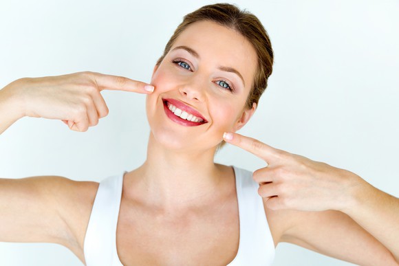 Smiling woman pointing at her teeth